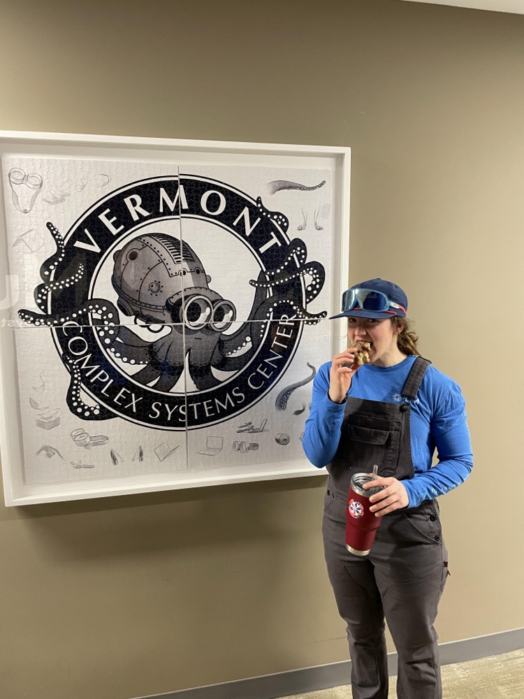 Mariah standing next to the Vermont Complex Systems Center logo
